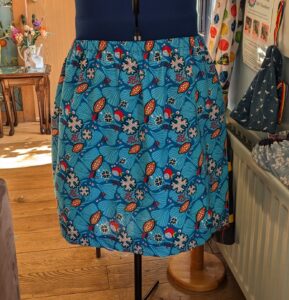 Blue, yellow, red and white tropical print gathered skirt on dress making form